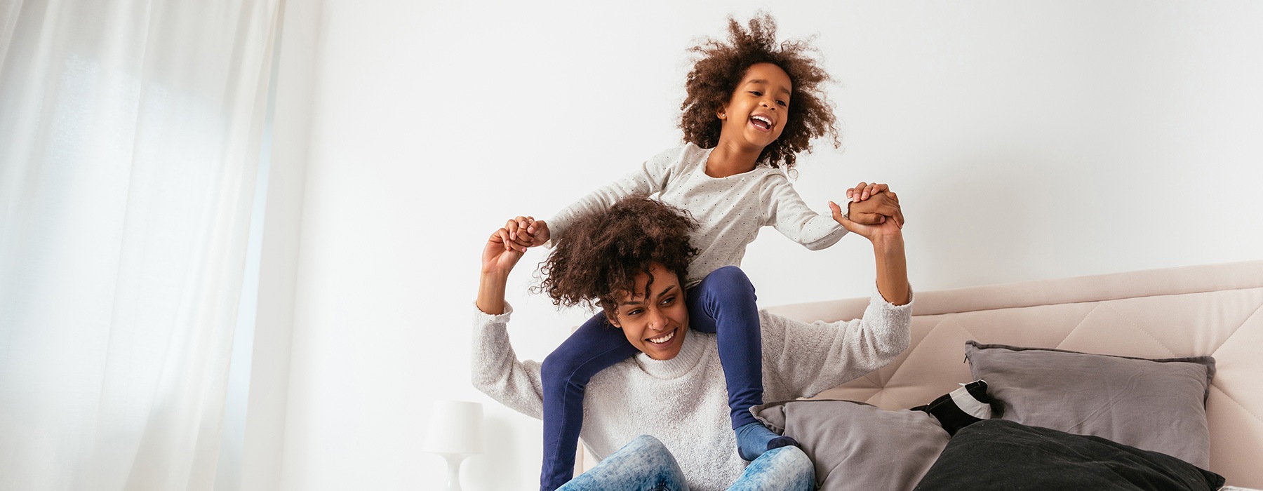 lifestyle image of a mom and child playing in a bright bedroom